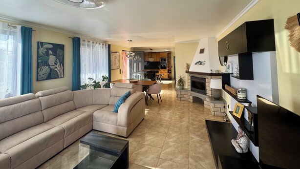 Een moderne woonkamer met een bank, salontafel en een open haard.