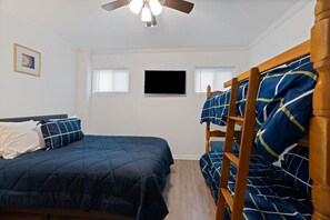 A bedroom with a bed, a ceiling fan, a TV, and a window. - A Lakeview Getaway in Guntersville, AL (Guntersville)