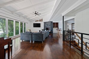 A spacious living room with a fireplace, a large sofa, and a dining area with a view of the outdoors. - A Lakeview Getaway in Guntersville, AL (Guntersville)