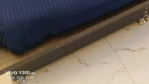 A bed with a blue and beige bedspread, two pillows, and a wooden headboard. - Hotel Rameshwaram Inn (Rishikesh)