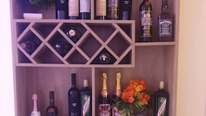 Una botellera de madera con varias repisas que exhiben diferentes botellas de vino y champán.