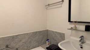 Ein Badezimmer mit einem weißen Waschbecken, einem Spiegel, einem Handtuch und einer Seife.