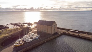 Un bâtiment situé sur la côte, doté d’un quai et de plusieurs bateaux.
