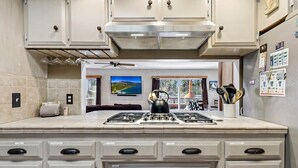 Une cuisine dotée d’un îlot central, de meubles de rangement, d’une cuisinière et d’un ventilateur de plafond.