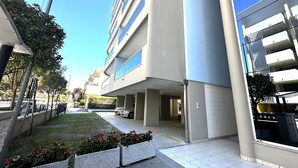 Ein modernes Mehrgeschosshaus mit großen Fenstern und einem Parkplatz, auf dem ein Auto steht.