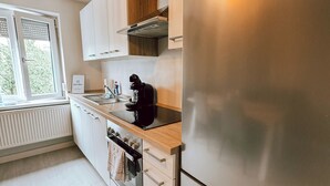 Een moderne keuken met roestvrijstalen apparatuur, houten kastjes en een raam dat voor natuurlijk licht zorgt.