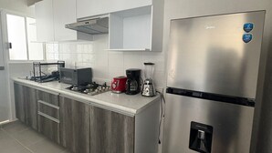 Una cocina moderna con armarios blancos, electrodomésticos de acero inoxidable y un tostador empotrado.