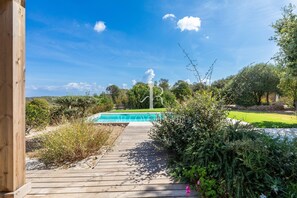 A wooden deck leading to a swimming pool surrounded by lush greenery and trees. - Villa Serena - 10 minutes from the beach (Bonifacio)