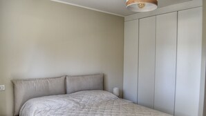 Et soveværelse med seng, natbord og garderobeskab.