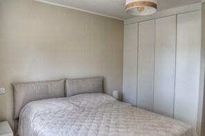 A bedroom with a bed, a nightstand, and a wardrobe. - Villa Serena - 10mn from the beach (Bonifacio)