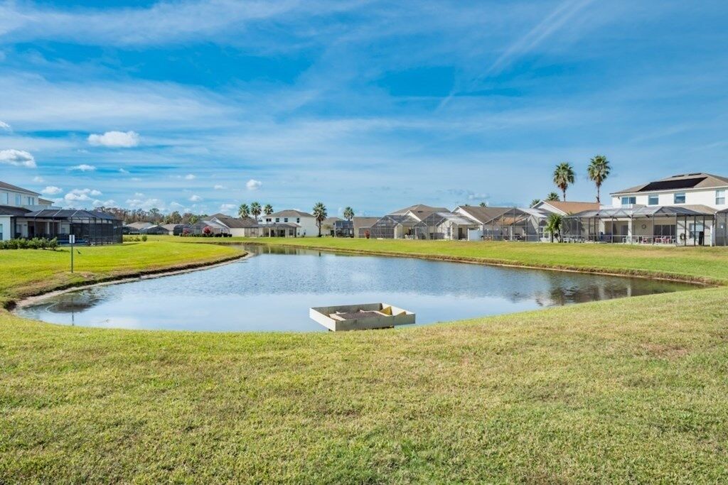 Uma área residencial com casas, um lago e céu limpo.