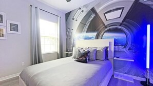 Una camera da letto con un letto, una finestra con tende, un murale a parete e una ventola a soffitto.