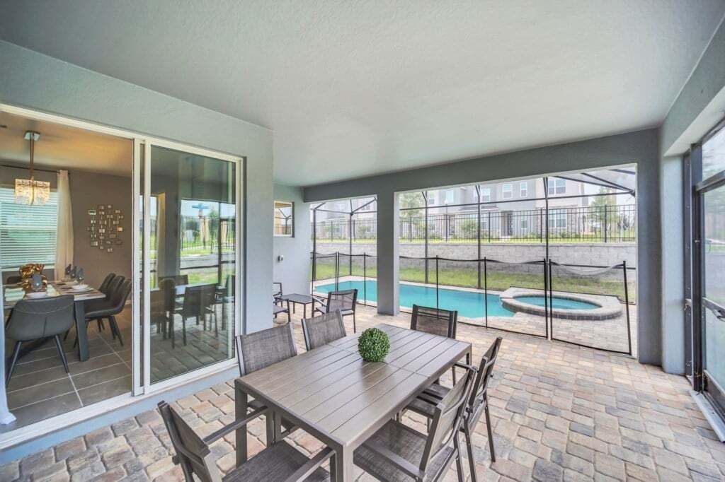 Eine Terrasse mit Esstisch und Stühlen, ein kleiner Pool und Blick auf eine Wohngegend.