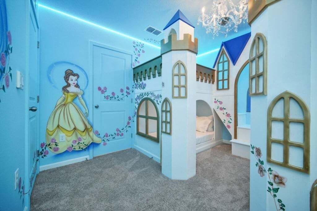 A children's playroom with a castle-themed design, including a mural of a princess and a castle structure.