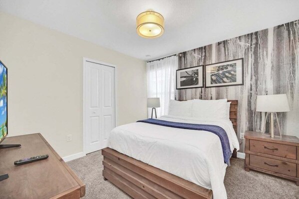 A bedroom with a bed, bedside tables, a lamp, and a television. - Luxury Pool/spa Home With Lots Of Sunshine! 6 Bedroom Villa (Davenport)