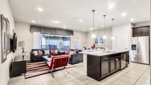 A modern kitchen with a central island, built-in appliances, and pendant lighting. - Beautiful Tranquil Relaxing Home With Private Pool 4 Bedroom Townhouse (Kissimmee)