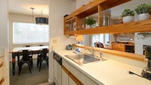 Una cucina con un piano di lavoro in legno, un lavello e un'area pranzo con sedie.