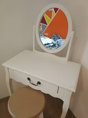 A white vanity with a round mirror, a wooden stool, and a single drawer. - Apartment '70m²' with Shared Garden, Balcony and Wi-Fi (Hayingen)