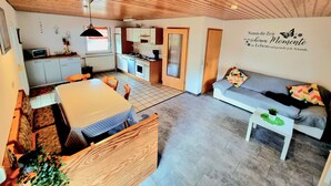 Un espacio habitable compacto con cocina, comedor y sofá.
