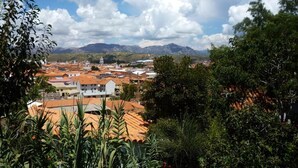 A town with red-roofed buildings, a prominent white tower, and mountains in the background. - La Selenita  (Sucre)