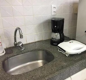 A kitchen with a stainless steel sink, a coffee maker, and a scale on the countertop. - Flat Com Vista Mar No Everest (Recife)