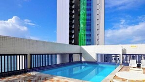 A rooftop swimming pool with checkered flooring, a pool table, and outdoor seating. - Flat Com Vista Mar No Everest (Recife)