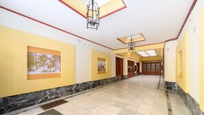 A corridor with yellow walls, framed pictures, and a tiled floor. - M Nda11bii Acogedor Estudio Interior con Todas la (Madrid)