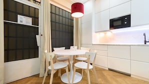 A modern kitchen with white cabinets, a microwave, and a round dining table with chairs. - M Nda11bii Acogedor Estudio Interior con Todas la (Madrid)