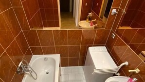 A bathroom with a bathtub, a toilet, and a sink. - Fantastic Inn Warsaw - CH10 (Warsaw)