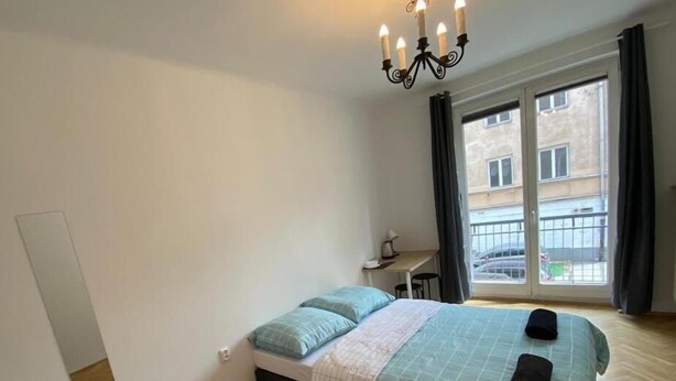 A bedroom with a bed, a desk, and a window with curtains. - Fantastic Inn Warsaw - CH10 (Warsaw)