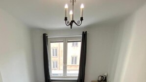 A small, well-lit bedroom with a bed, a desk, and a window with curtains. - Fantastic Inn Warsaw - CH10 (Warsaw)