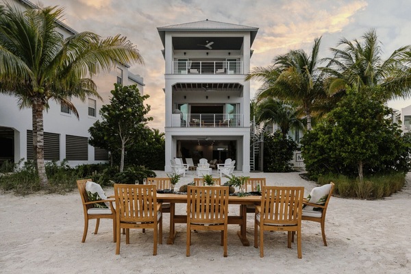 Waterfront outdoor dining with palm views and sunset backdrop.