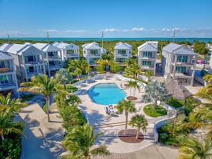 A resort with multiple buildings, a central swimming pool, and palm trees. - Casa Pilar at Seaglass Cove (Marathon)