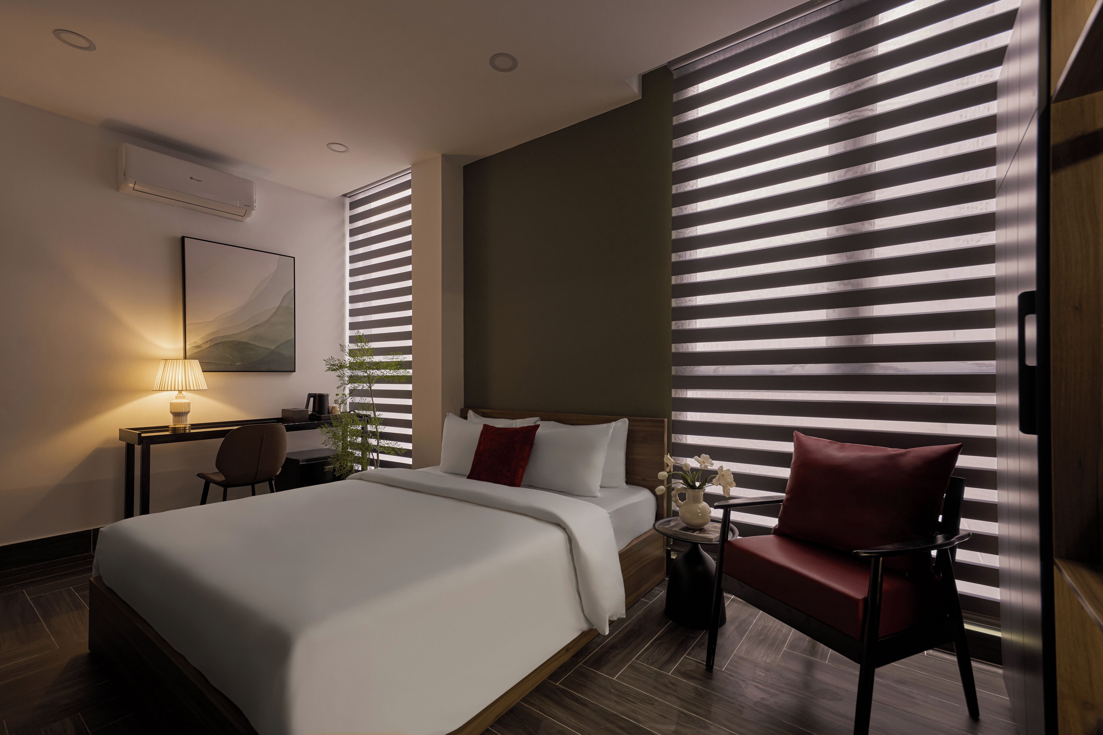 Ein modernes Hotelzimmer mit einem großen Bett, einem Schreibtisch und einem Sessel.