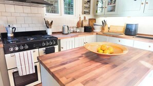 A kitchen with a wooden countertop, a stove, and a bowl of lemons. - Lewes Sauna House · Characterful Interiors, Castle Views (East Sussex)