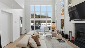 Ett rymligt vardagsrum med en stor soffa, en öppen spis och en tv.