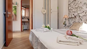 Ein Hotelzimmer mit einem ordentlich bezogenen Bett, einer Nachttischlampe und einer dekorativen Wandverkleidung.