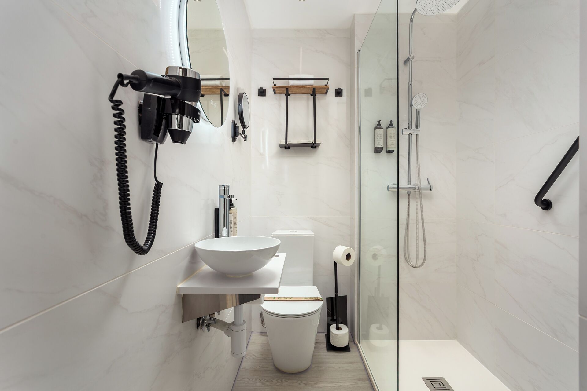 A modern bathroom with a large mirror, a sink, a toilet, and a shower area.