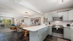 A modern kitchen with a large island, built-in oven, and microwave. - Hi Country Haus Unit 2110 Spacious 2 bed, river views walk to downtown (Winter Park)