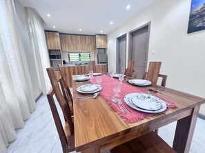 Un comedor con una mesa de madera dispuesta para seis personas, rodeada de sillas.