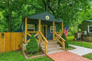 A small building with a porch, steps, and an American flag.