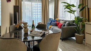 Un salon moderne comprenant un coin repas, un canapé et une grande plante.