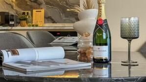 Une bouteille de champagne Moët & Chandon, un verre et un vase décoratif sur une table en marbre.