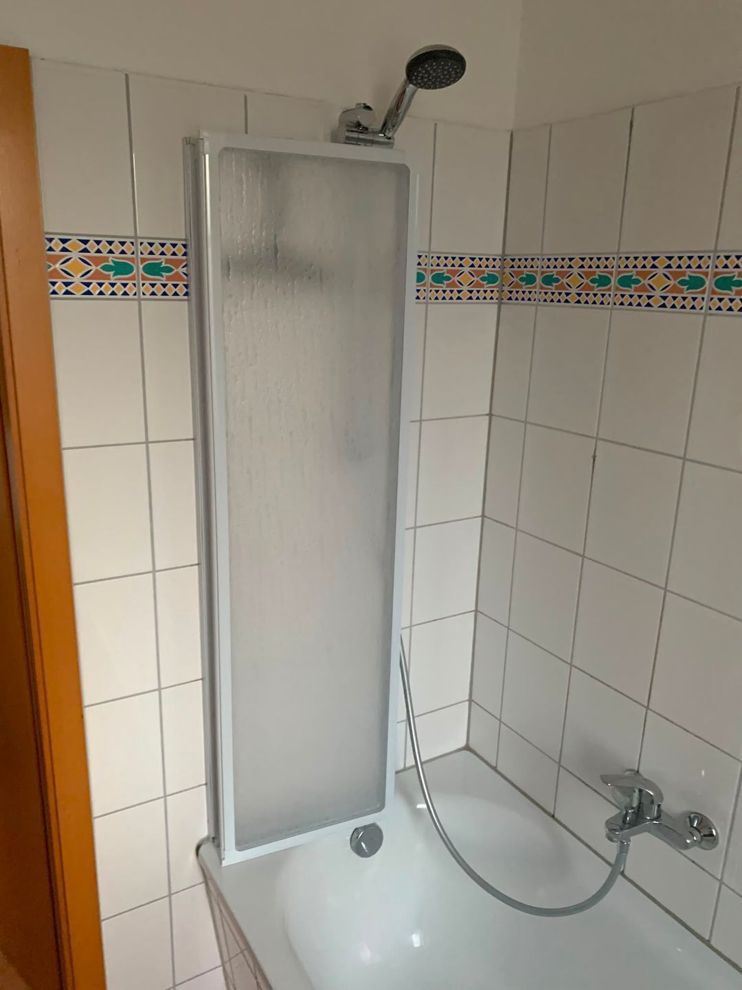 Un baño con cabina de ducha, bañera y detalles decorativos en azulejos.