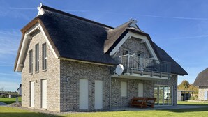 A two-story stone house with a sloped roof, a balcony, and a satellite dish. - Vacation apartment Kajüte 2 - close to the harbor, with balcony - Fully equipped (Poseritz)