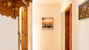 A hallway with wooden doors, a framed picture on the wall, and a wooden ceiling. - Vacation home zum Kranichblick - for families + dog - Zum Kranichblick: Relaxing (Garz OT Losentitz)