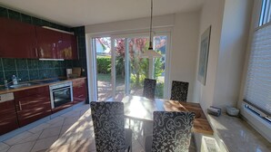 Een moderne keuken met een eetgedeelte, grote ramen en uitzicht op de omgeving.