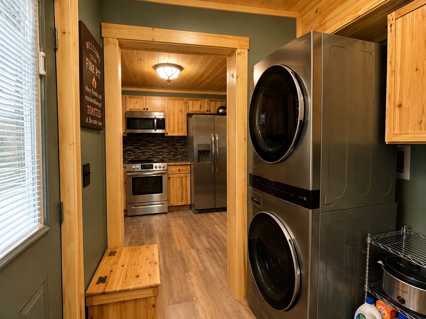 A compact kitchen with stainless steel appliances, wooden cabinetry, and a built-in oven.