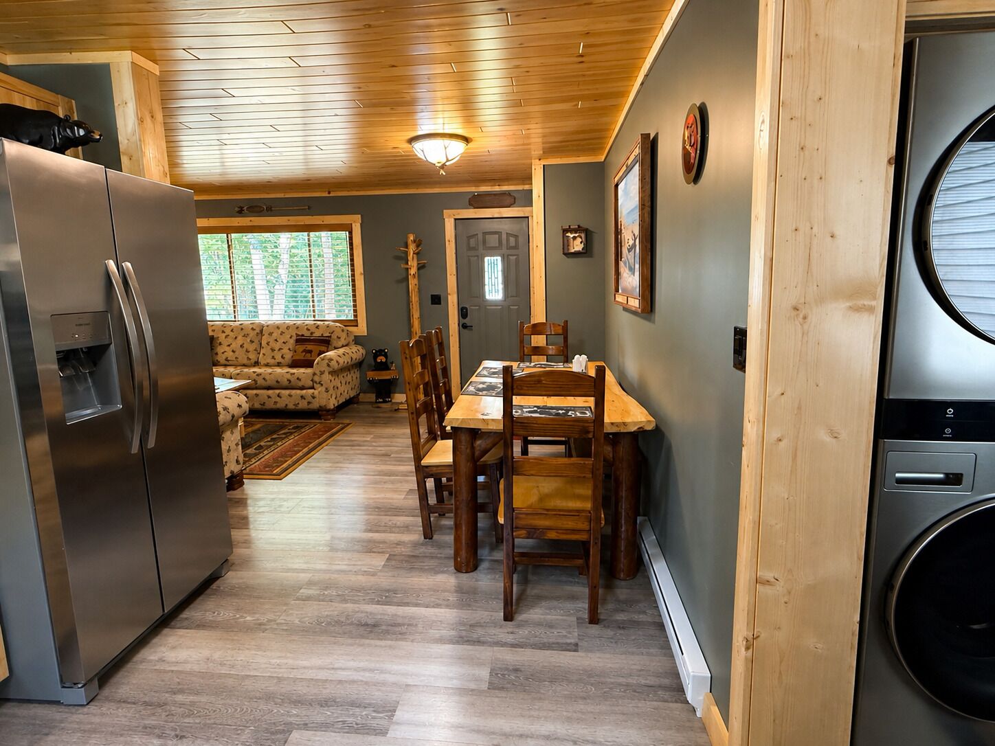 A compact kitchen with a refrigerator, dining table, and chairs.