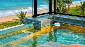 A infinity pool with a view of the beach and ocean.